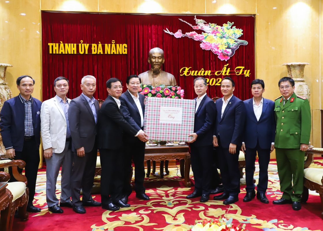 Trưởng ban Nội chính Trung ương Phan Đình Trạc (thứ 5, trái sang) trao quà chúc Tết lãnh đạo thành phố. Ảnh: NGỌC PHÚ