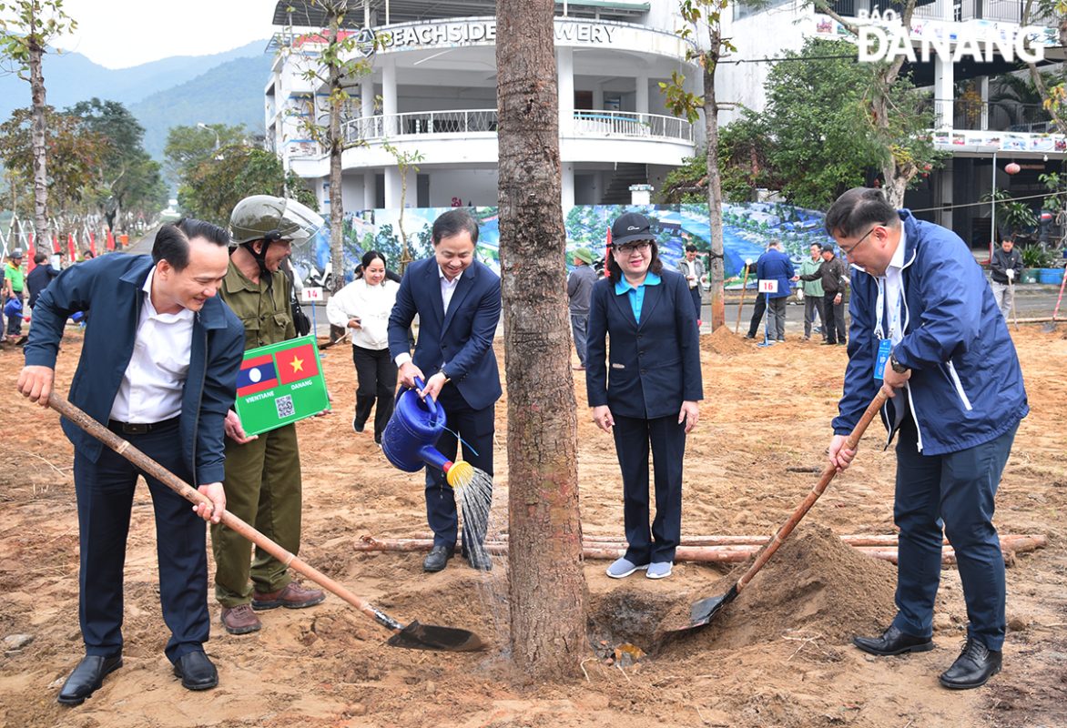 Phó Bí thư Thường trực Thành ủy Nguyễn Đình Vĩnh (bên trái) trồng cây cùng đại biểu của Thủ đô Viêng Chăn (Lào) (bên phải). Ảnh: T.PHƯƠNG