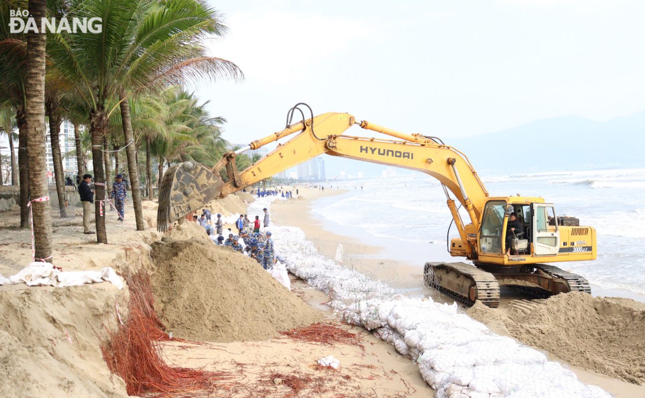 Thành phố Đà Nẵng đã huy động các lực lượng, phương tiện cơ giới tham gia xử lý khẩn cấp tình trạng xói lở tại bãi biển Mỹ Khê vào tháng 1-2025. Ảnh: HOÀNG HIỆP