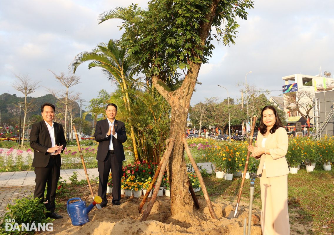 Chủ tịch HĐND thành phố Đà Nẵng Ngô Xuân Thắng (thứ 2, từ trái sang) và Bí thư Quận ủy Ngũ Hành Sơn Mai Thị Ánh Hồng (bìa phải) phấn khởi trồng xong một cây nhãn lồng trong công viên, vườn hoa danh thắng Ngũ Hành Sơn. Ảnh: HOÀNG HIỆP