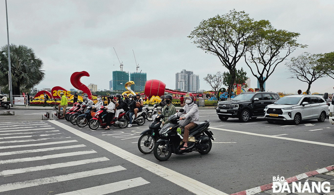 Người dân chấp hành quy định dừng xe khi gặp đèn đỏ. Ảnh: THÀNH LÂN