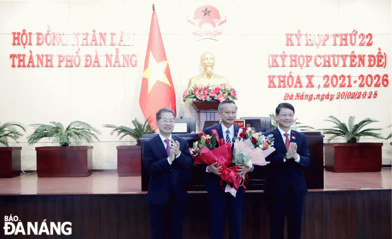 Bí thư Thành ủy Nguyễn Văn Quảng (bên trái) và Chủ tịch HĐND thành phố Ngô Xuân Thắng (bên phải) tặng hoa, chúc mừng tân Phó Chủ tịch HĐND thành phố Đoàn Ngọc Hùng Anh. Ảnh: TRỌNG HUY
