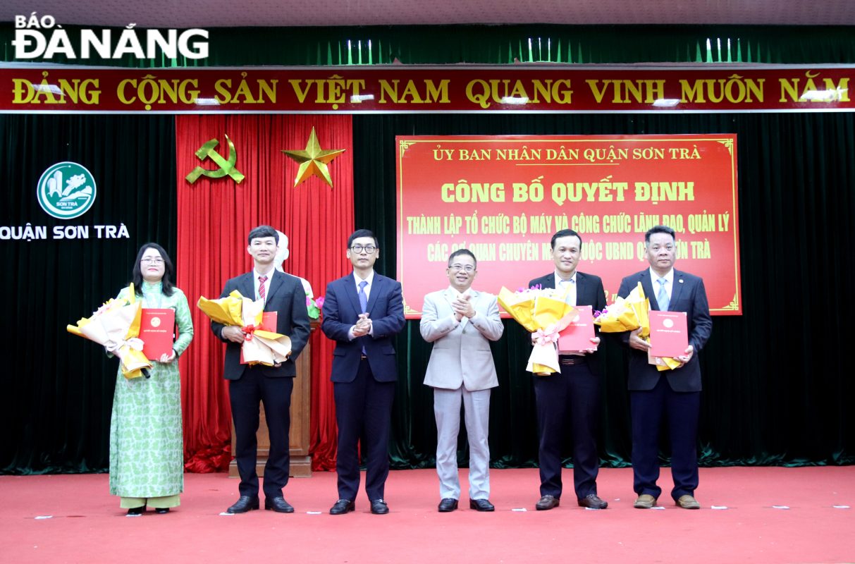 Lãnh đạo quận Sơn Trà trao quyết định, tặng hoa chúc mừng các trưởng phòng mới được bổ nhiệm. Ảnh: T. HUY