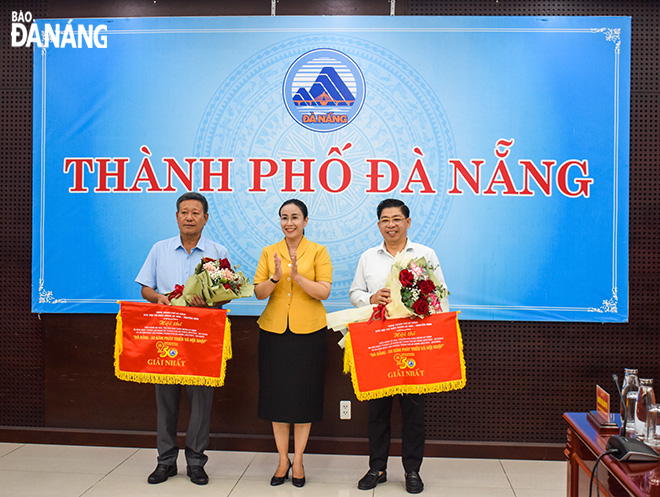 Phó Chủ tịch UBND thành phố Nguyễn Thị Anh Thi trao giải nhất cho quận Hải Châu và Công ty cổ phần đầu tư phát triển du lịch Aion. Ảnh: ĐOÀN HẠO LƯƠNG