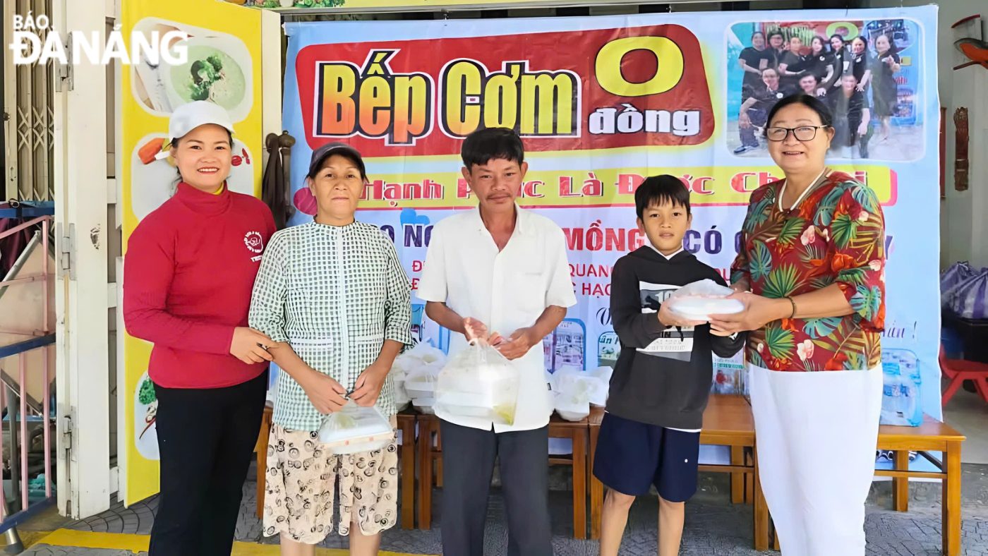 Người dân nhận suất cơm chay miễn phí từ thành viên CLB “Sống để yêu thương” tại điểm phát 357 Khúc Hạo, quận Sơn Trà.