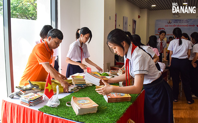 Các em học sinh cùng thầy cô thư viện tham gia thi xếp sách. Ảnh: ĐOÀN HẠO LƯƠNG