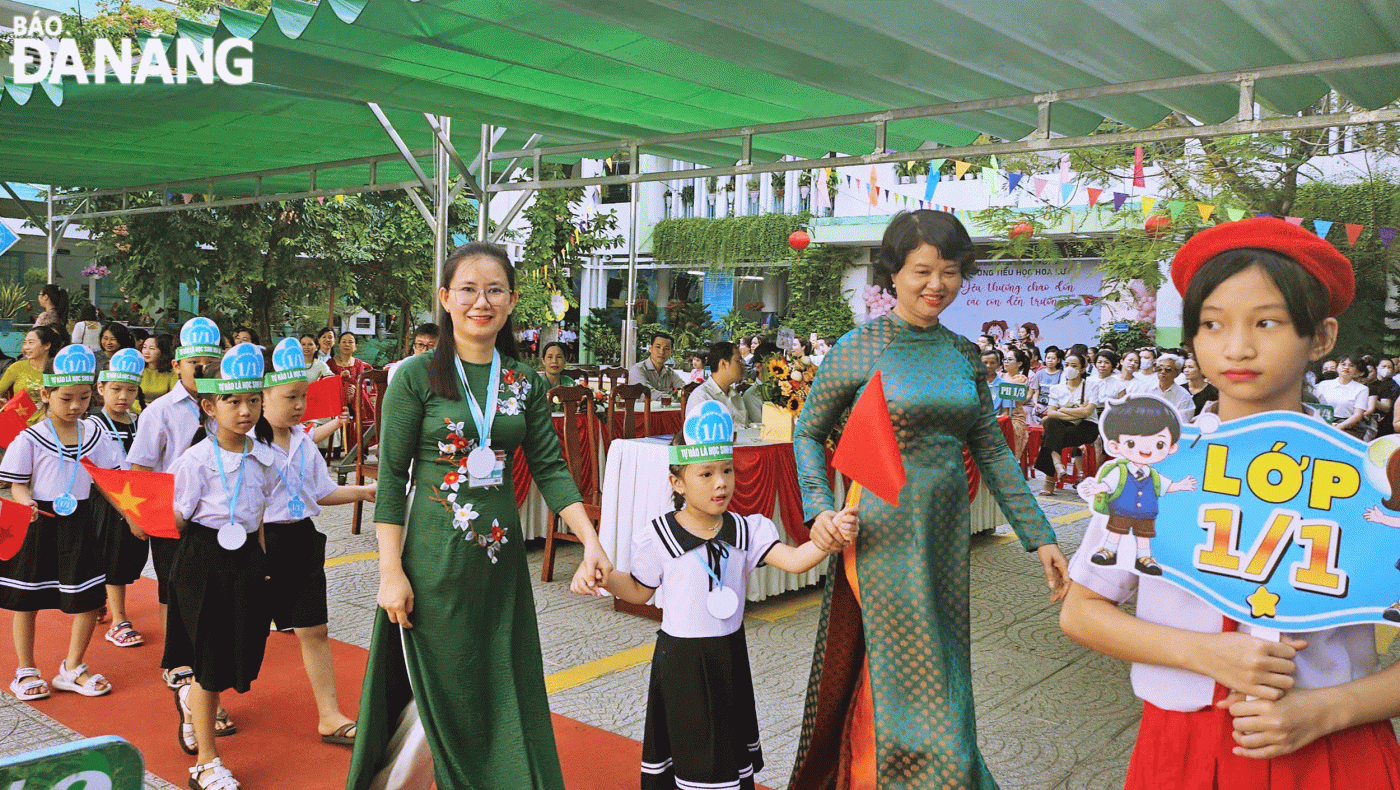 Giáo viên Trường Tiểu học Hoa Lư (quận Thanh Khê) đón học sinh vào lớp năm học 2024-2025. Ảnh: NGỌC HÀ