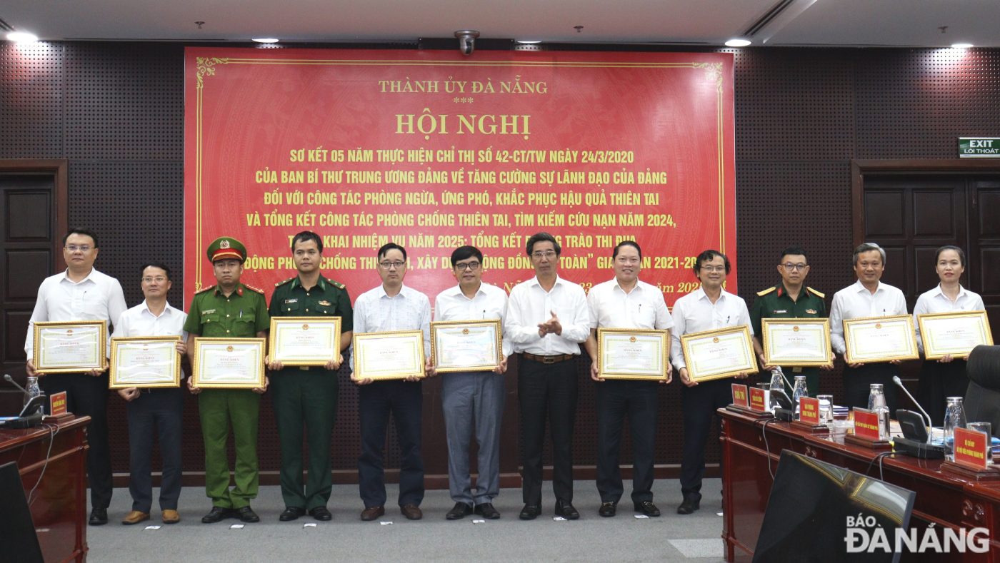 Phó Chủ tịch UBND thành phố Trần Chí Cường (thứ 7, từ trái sang) trao Bằng khen của Chủ tịch UBND thành phố cho các tập thể có thành tích xuất sắc trong phong trào thi đua “Chủ động phòng chống thiên tai, xây dựng cộng đồng an toàn” giai đoạn 2021-2025. Ảnh: HOÀNG HIỆP