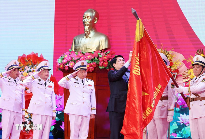 Chủ tịch nước Lương Cường gắn Huân chương Hồ Chí Minh lên lá cờ truyền thống của Hải quân nhân dân Việt Nam. (Ảnh: TTXVN)