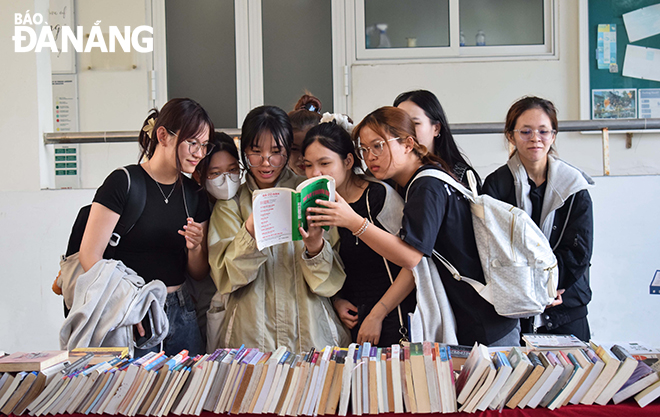 Sinh viên Trường Đại học Ngoại ngữ (Đại học Đà Nẵng) tham gia tuần lễ sách tại khuôn viên nhà trường. Ảnh: ĐOÀN HẠO LƯƠNG