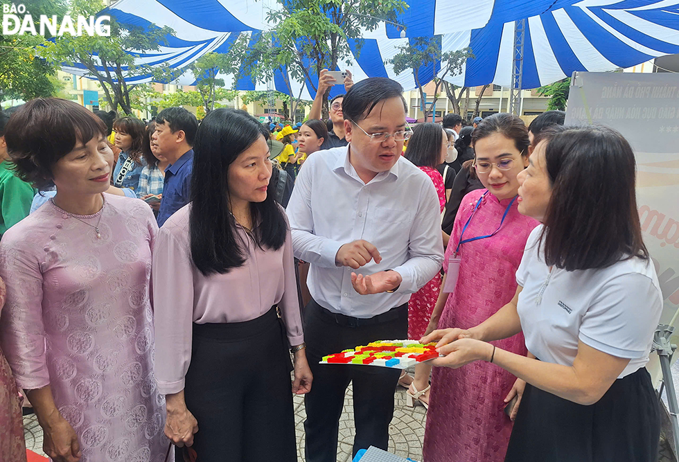 Lãnh đạo ngành giáo dục thành phố thăm các khu trưng bày sản phẩm sáng tạo. Ảnh: THU HÀ