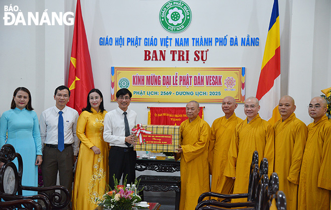 Trưởng ban Tuyên giáo và Dân vận Thành ủy Trần Thắng Lợi (thứ 4, bên trái sang) tặng quà chúc mừng Ban Trị sự Giáo hội Phật giáo Việt Nam thành phố. Ảnh: ĐẮC MẠNH
