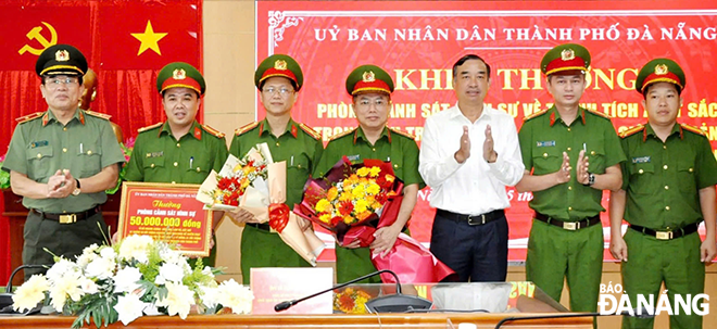 Chủ tịch UBND thành phố Lê Trung Chinh (áo trắng) khen thưởng Phòng Cảnh sát hình sự Công an thành phố vì thành tích xuất sắc trong đấu tranh tội phạm.  Ảnh: DOÃN HÙNG