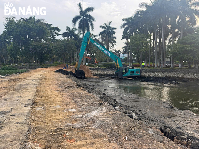 Hồ Công viên 29 Tháng 3 đang được đắp đê quai, hạ thấp mực nước vùng nạo vét và làm khô bùn trước khi vận chuyển lên đổ tại hố sâu các mỏ đá. Ảnh: HOÀNG HIỆP
