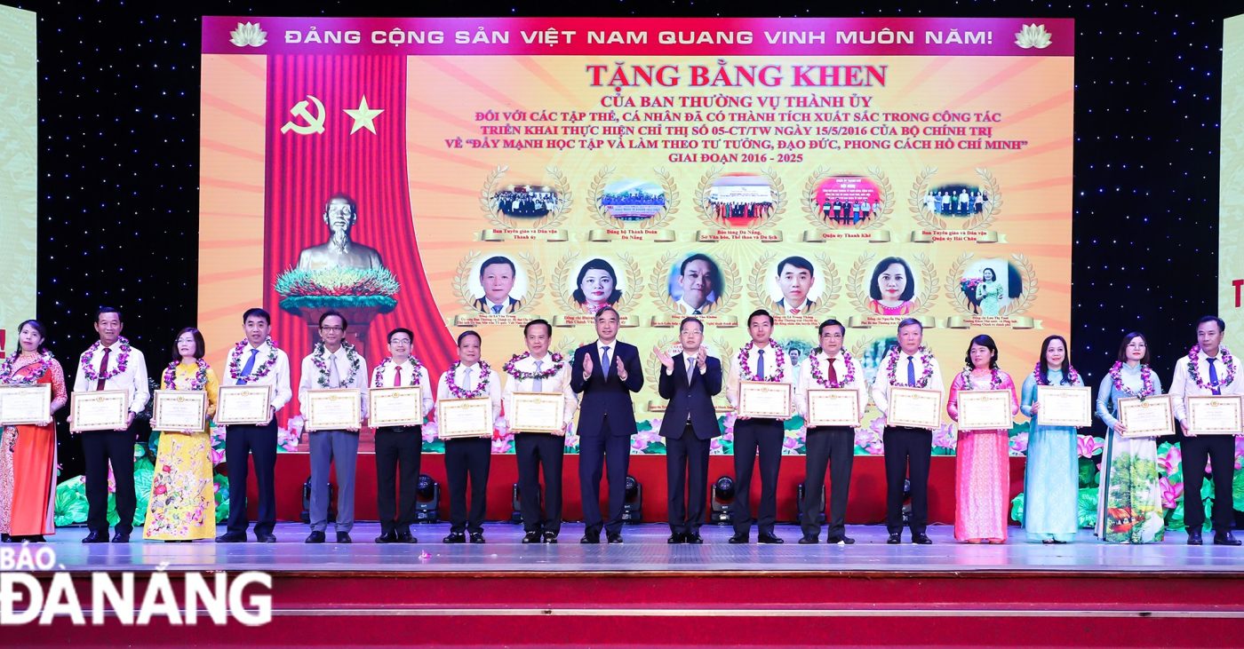 Bí thư Thành ủy Nguyễn Văn Quảng (thứ 8, phải sang) và Chủ tịch UBND thành phố Lê Trung Chinh (thứ 9, phải sang) trao bằng khen của Ban Thường vụ Thành ủy cho các tập thể, cá nhân. Ảnh: NGỌC PHÚ