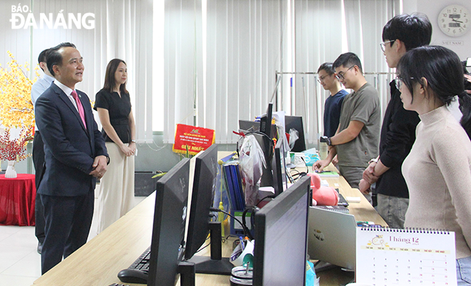 Phó Bí thư Thường trực Thành ủy Nguyễn Đình Vĩnh (bên trái) đến thăm hỏi người lao động tại Khu Công nghệ cao Đà Nẵng. Ảnh: X. Hậu