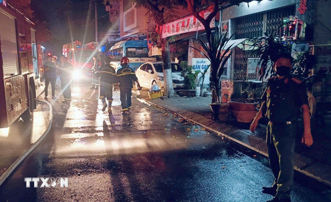 Lực lượng chức năng phong tỏa khu vực để chữa cháy. (Ảnh: TTXVN)