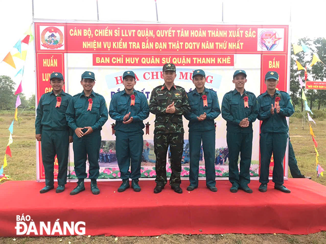 Thượng tá Lê Tất Quảng, Chính trị viên Ban Chỉ huy Quân sự quận Thanh Khê (giữa) tặng hoa bắn giỏi cho các chiến sĩ dân quân trong kiểm tra bắn đạn thật cuối khóa huấn luyện.  Ảnh: ANH ĐỨC
