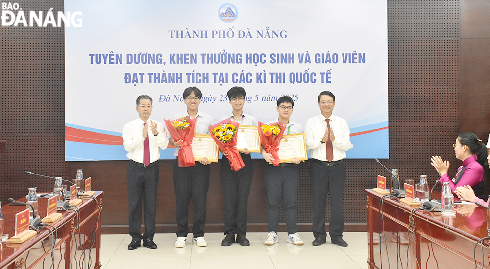 Ủy viên Trung ương Đảng, Bí thư Thành ủy, Trưởng đoàn Đại biểu quốc hội thành phố Nguyễn Văn Quảng; Ủy viên Ban Thường vụ Thành ủy, Chủ tịch HĐND thành phố Ngô Xuân Thắng trao bằng khen cho các em học sinh. Ảnh: THU HÀ.