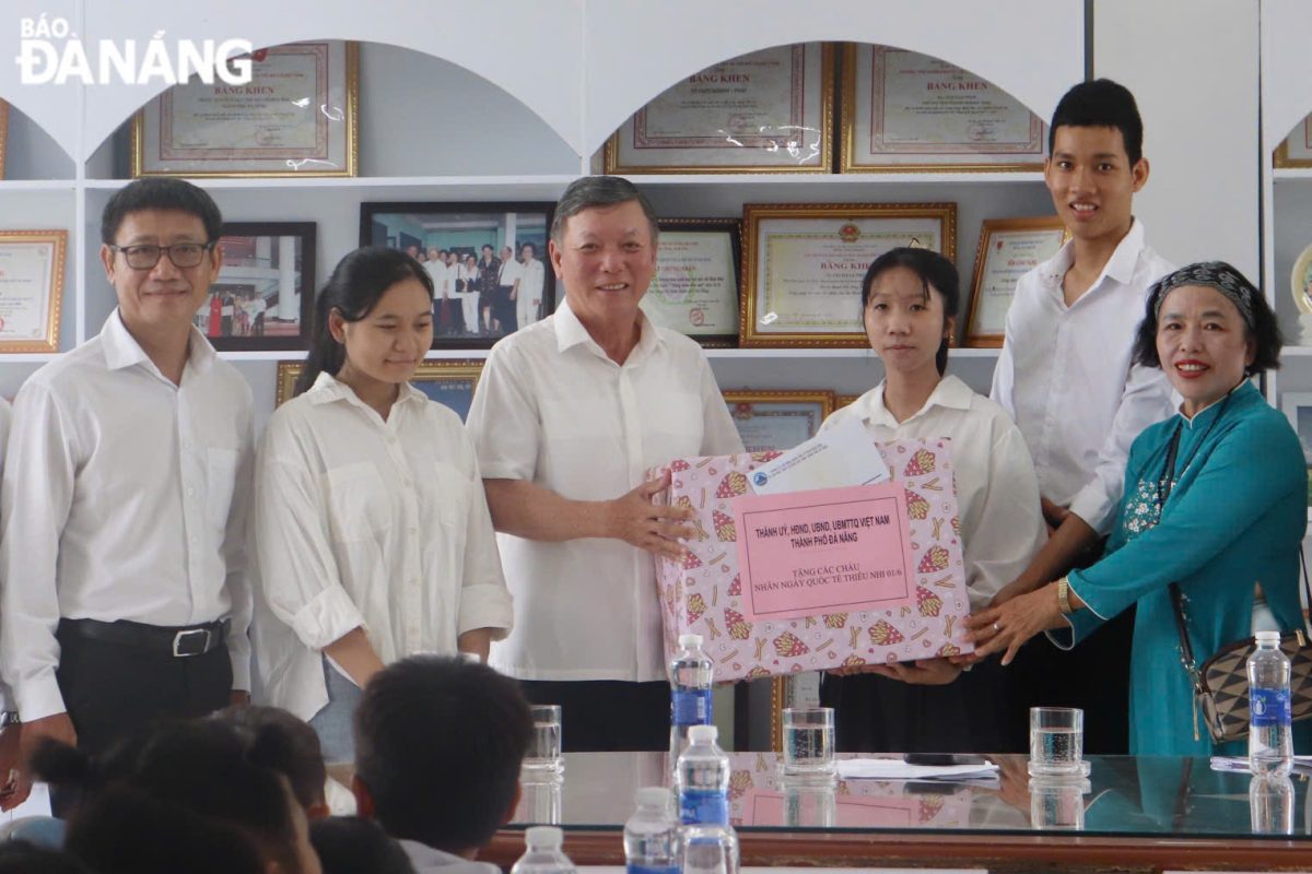 Chủ tịch Ủy ban MTTQ Việt Nam thành phố Lê Văn Trung (thứ 3, bên trái sang) tặng quà cho các em tại Trung tâm Nuôi dạy trẻ mồ côi Hoa Mai. Ảnh: KHÁNH NGÂN