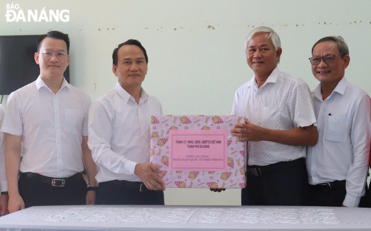 Phó Bí thư Thường trực Thành ủy Nguyễn Đình Vĩnh (thứ 2, bên trái sang) tặng quà Trung tâm Nuôi dạy trẻ mồ côi. Ảnh: KHÁNH NGÂN