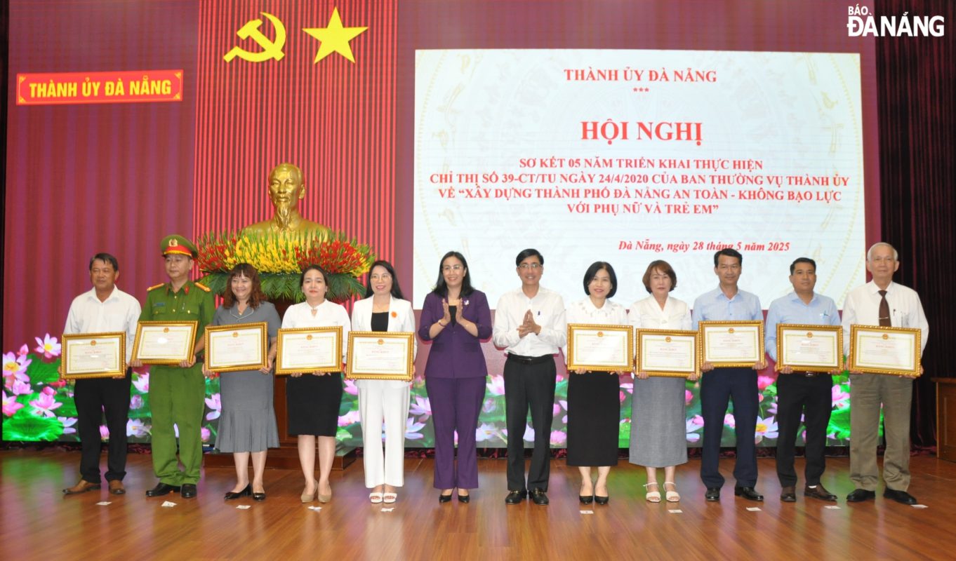Trưởng ban Tuyên giáo và Dân vận Thành ủy Trần Thắng Lợi (thứ 6, bên phải sang) và Phó Chủ tịch UBND thành phố Nguyễn Thị Anh Thi (thứ 6, bên trái sang) tặng bằng khen cho các tập thể có thành tích xuất sắc trong triển khai thực hiện Chỉ thị số 39-CT/TU. Ảnh: LÊ HÙNG