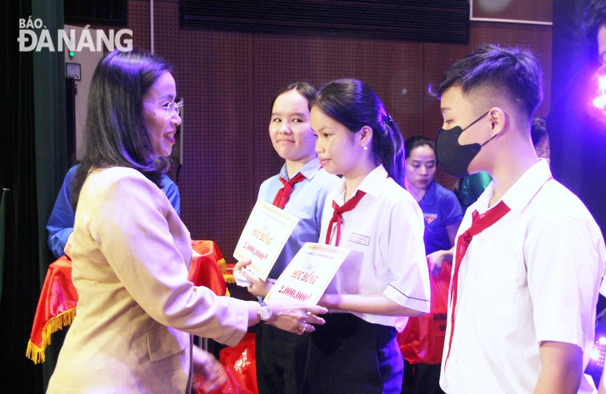 Phó Chủ tịch UBND thành phố Nguyễn Thị Anh Thi (bên trái) trao học bổng cho trẻ em vượt khó, học giỏi. Ảnh: L.P