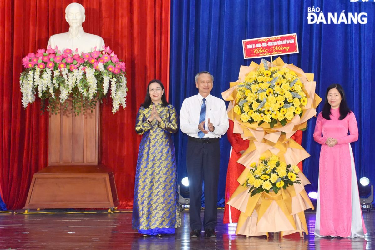 Phó Chủ tịch HĐND thành phố Đoàn Ngọc Hùng Anh (thứ 2, trái sang), Phó Chủ tịch UBND thành phố Nguyễn Thị Anh Thi (bên trái) tặng hoa chúc mừng ngành Giáo dục và Đào tạo. Ảnh: THU HÀ.