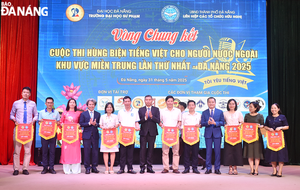 Phó Chủ tịch Thường trực UBND thành phố Hồ Kỳ Minh tặng cờ lưu niệm cho các đại diện tham dự tại cuộc thi. Ảnh: THU HÀ.