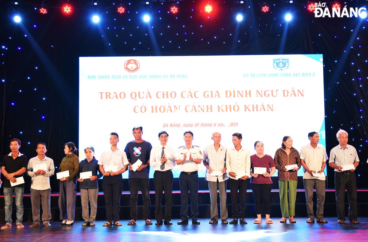 Trưởng ban Tuyên giáo và Dân vận Thành uỷ Trần Thắng Lợi và Đại tá Doãn Ngọc Triết, Phó Tư lệnh Pháp luật Bộ Tư lệnh Vùng Cảnh sát biển 2 (ở giữa) trao quà cho các hộ ngư dân có hoàn cảnh khó khăn. Ảnh: T.PHƯƠNG