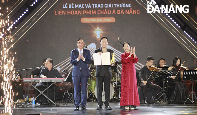 Chủ tịch UBND thành phố Lê Trung Chinh (bên trái) trao giải phim Việt Nam dự thi hay nhất cho bộ phim