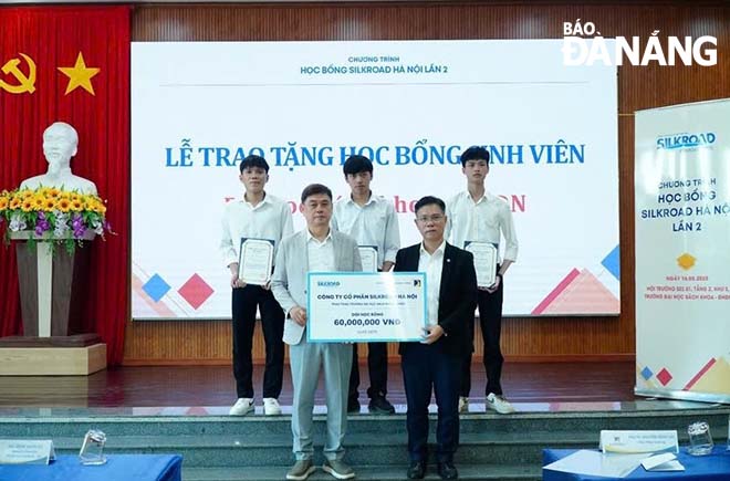 Đại diện doanh nghiệp trao học bổng cho các sinh viên Trường Đại học Bách khoa. Ảnh: NHẬT HẠ