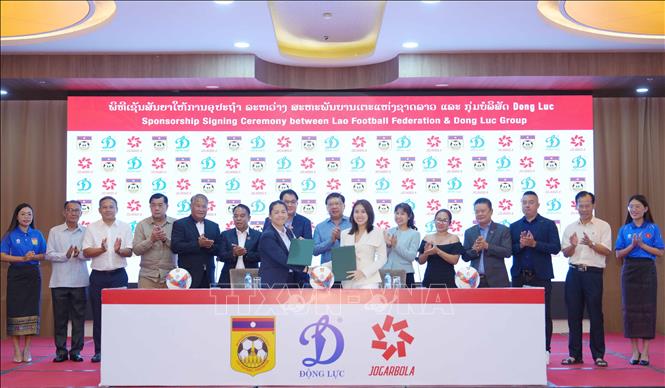 Đại diện Tập đoàn thể thao Động Lực và đại diện Liên đoàn bóng đá Lào trao đổi thỏa thuận ký kết hợp tác. Ảnh: Xuân Tú/PV TTXVN tại Lào