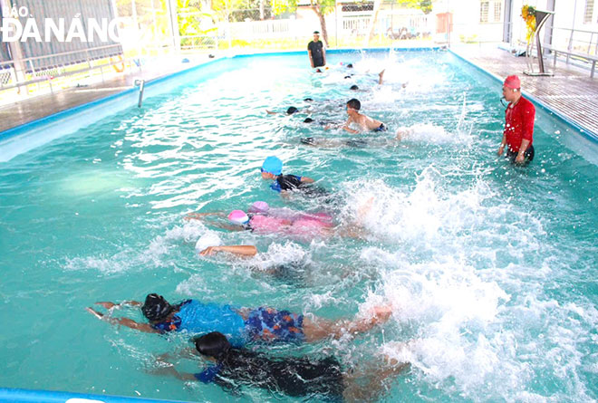 Giáo viên Trường Tiểu học Trần Đại Nghĩa hướng dẫn học sinh các kỹ thuật bơi cơ bản. Ảnh: LAM PHƯƠNG