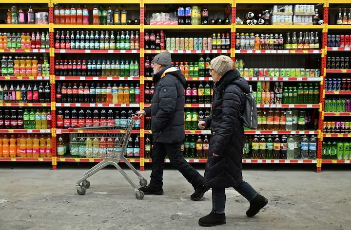 Người tiêu dùng mua sắm tại một cửa hàng tạp hóa ở thành phố Omsk (Nga).  Ảnh: REUTERS/Alexey Malgavko