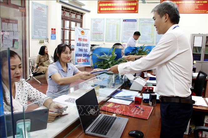 Công chức Bộ phận một cửa UBND phường Thọ Xương, thành phố Bắc Giang trả kết quả thủ tục hành chính cho người dân. Ảnh minh họa: TTXVN