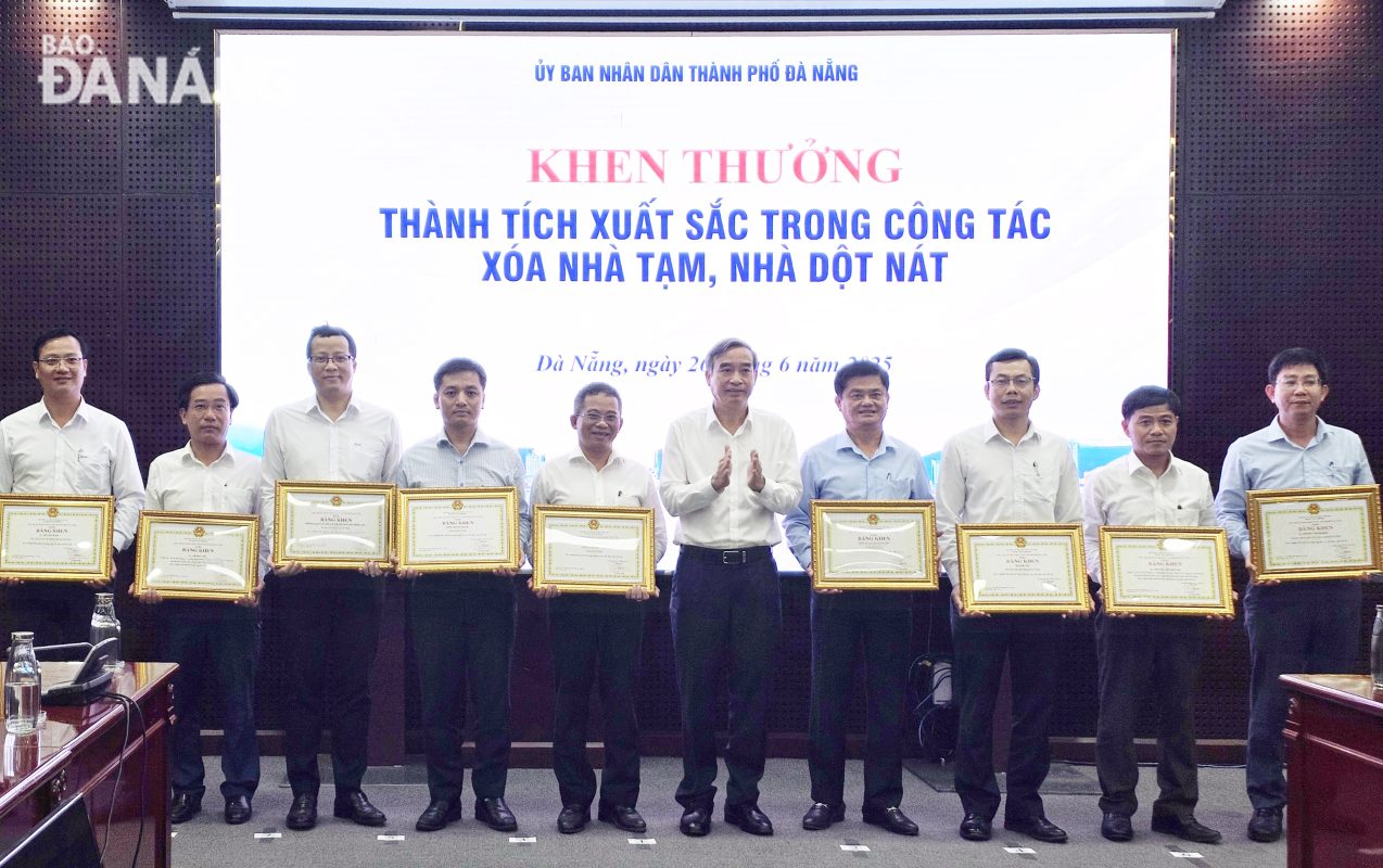 Chủ tịch UBND thành phố Lê Trung Chinh () trao bằng khen cho các tập thể, cá nhân có thành tích xuất sắc trong công tác xóa nhà tạm, nhà dột nát. Ảnh: LAM PHƯƠNG